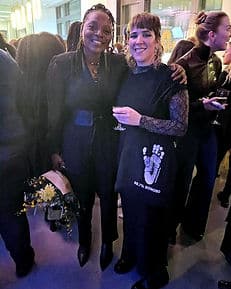 Two women looking at camera at evening event