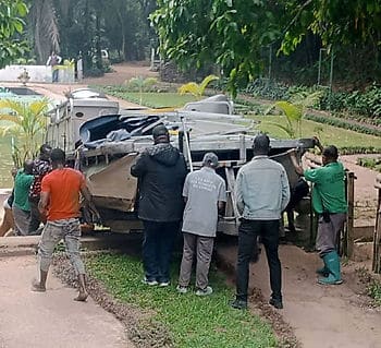 Staff of Lola ya Bonobo help move Queens filming boat from sanctuary entrance to the lake.