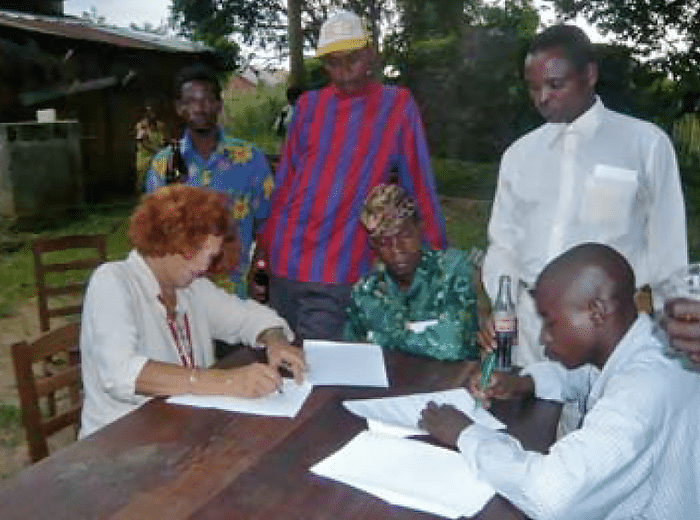 Claudine Andre signing agreement for Ekolo ya Bonobo forest with dignitaries from Ilonga Mpoo community.