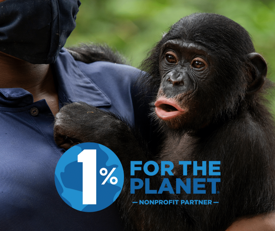 A baby bonobo held by a caregiver whose face cannot be seen.1% for the Planet logo.
