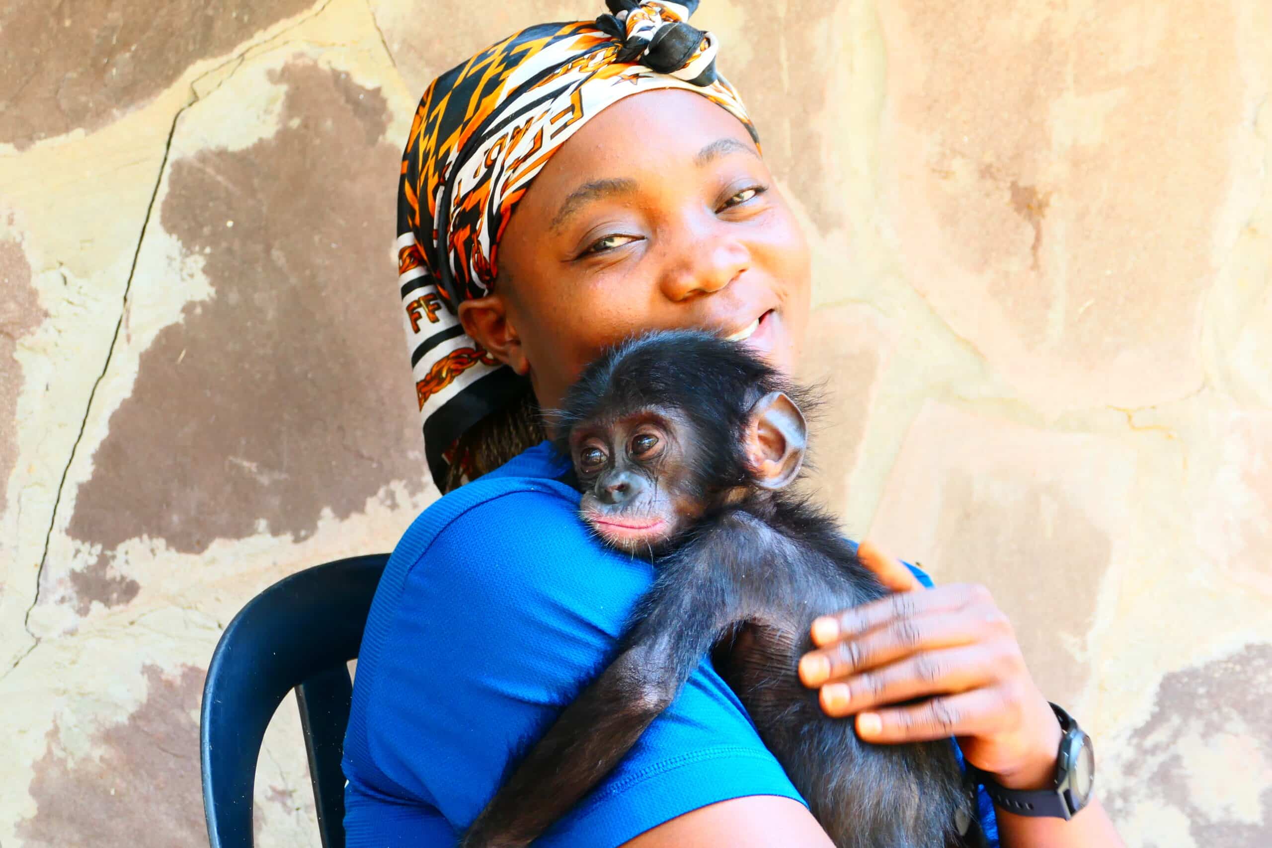 Mama Peguy with baby bonobo orphan Lombo on her chest.