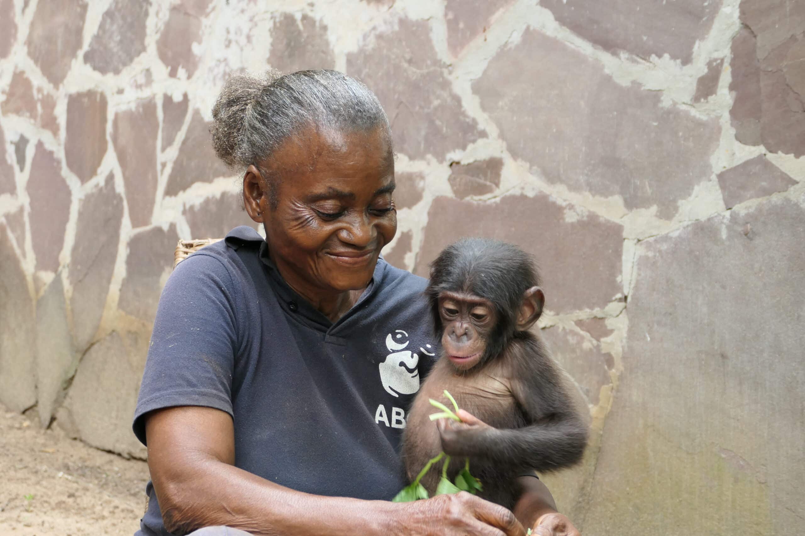 Mama Micheline holds baby bonobo orphan Lenda.